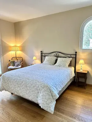 a bedroom with a large bed and a window at Les Lauriers Roses air-conditioned villa with garden and swimming pool in Saumane-de-Vaucluse