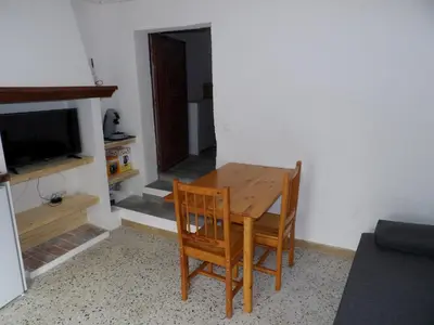 a dining room table with two chairs and a television at Studio chez Steph in Eyguières
