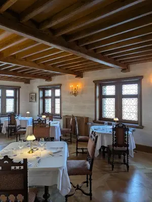 a dining room with white tables and chairs and windows at Domaine Jourdan in Le Puy-Sainte-Réparade