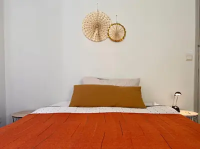 a bedroom with a bed with a orange blanket at Aix center in Aix-en-Provence