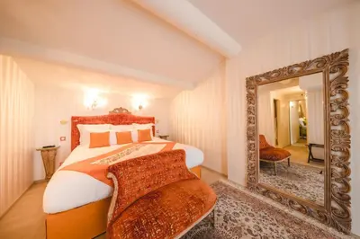 a bedroom with a large mirror and a bed at Le Palais d'Aglaé, Hôtel de Charme in Gordes