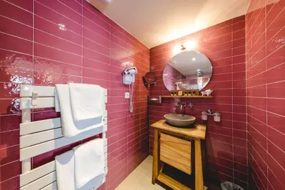 a bathroom with red tiles and a sink at Le Palais d'Aglaé, Hôtel de Charme in Gordes