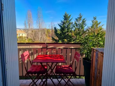 a red table and two chairs on a balcony at Appartement 2 Queenbed parking clim wifi in Aix-en-Provence