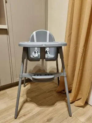 a high chair with a table and a controller at Appartement 2 Queenbed parking clim wifi in Aix-en-Provence