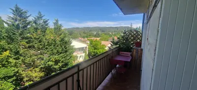 a balcony with a bench and a view of trees at Appartement 2 Queenbed parking clim wifi in Aix-en-Provence
