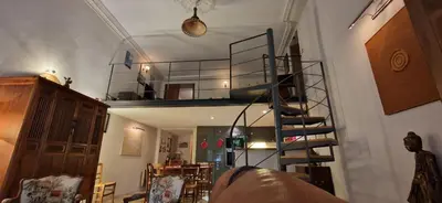 a living room with a spiral staircase in a house at Le Jardin secret 100m Mairie in Aix-en-Provence