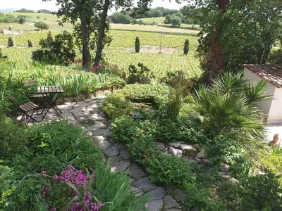 a garden with a bench and some plants and flowers at Chambre d'hôtes in La Tour-dʼAigues