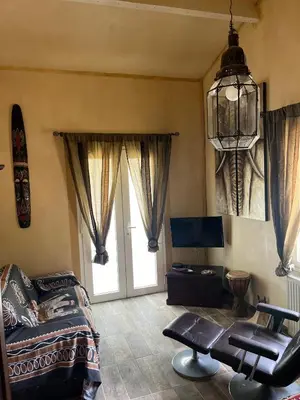 a living room with a bed and a chandelier at Chambre d'hôtes in La Tour-dʼAigues