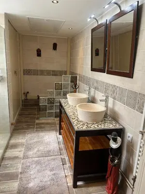 a bathroom with two sinks and a shower at Chambre d'hôtes in La Tour-dʼAigues