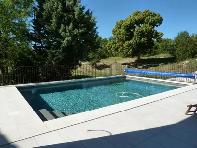 a swimming pool in a yard with a fence at La Grange des Davids Mas en Provence in Oppedette