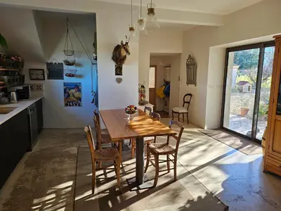 a kitchen and dining room with a wooden table and chairs at Mas des Grialou, grand mas provencal de standing in Carpentras