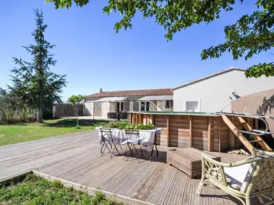a wooden deck with two chairs and a table at Holiday Home L' amandier by Interhome in Saint-Didier