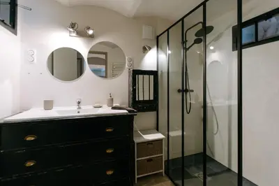 a bathroom with a black dresser and a shower at 