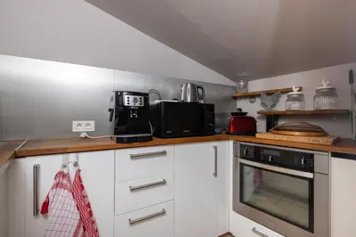 a kitchen with white cabinets and a stove top oven at SmartStay Mas Les Cedres - Proche Isle-sur-la-Sorgue in Lagnes