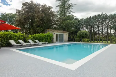 a swimming pool with chairs and an umbrella at SmartStay Mas Les Cedres - Proche Isle-sur-la-Sorgue in Lagnes