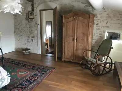 a living room with a chair and a cabinet at Clos de l'Abba in Gordes