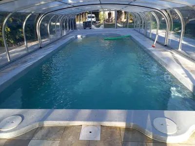 a pool of water in a green house at Le Coin Retro pour séjour romantique avec piscine chauffée in Le Thor