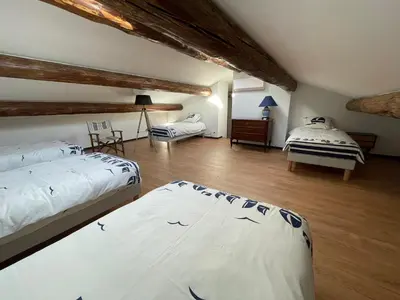 a large room with two beds and a table at Mas Chamsomat in Robion en Luberon