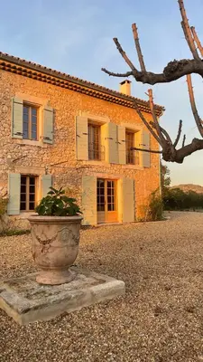 a large brick house with a pot in front of it at Mas Chamsomat in Robion en Luberon