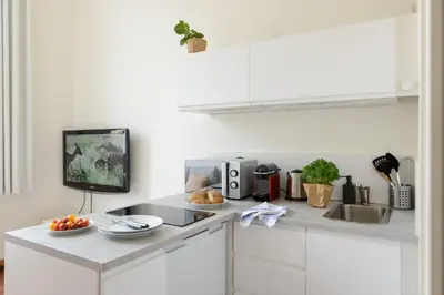 a kitchen with a counter with a sink and a tv at Cocon provençal dans le centre historique in Aix-en-Provence