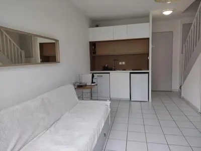 a living room with a couch and a kitchen at La provençale in Saint-Saturnin-lès-Avignon