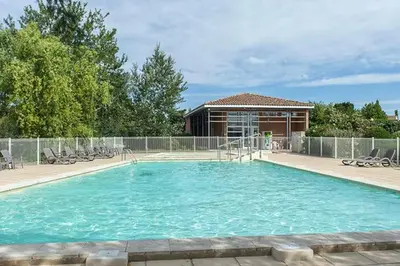 a large swimming pool with chairs in front of a building at La provençale in Saint-Saturnin-lès-Avignon