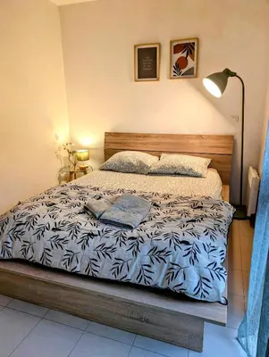 a bedroom with a bed with a blue and white comforter at L'instant sorgue in LʼIsle-sur-la-Sorgue