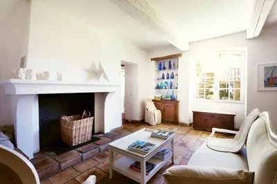 a living room with a couch and a fireplace at Domaine de Canfier, maison d'hôtes in Robion en Luberon