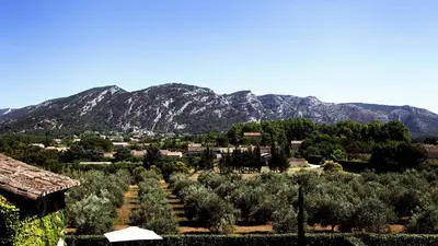 a village with trees and mountains in the background at Domaine de Canfier, maison d'hôtes in Robion en Luberon