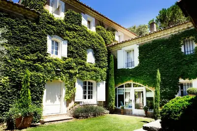 a building covered in ivy with a yard at Domaine de Canfier, maison d'hôtes in Robion en Luberon
