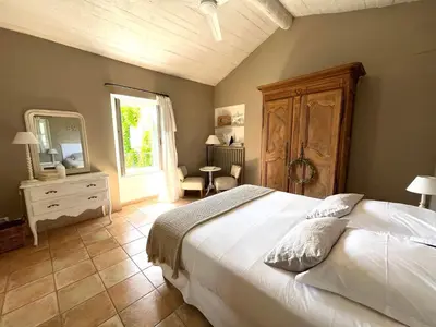 a bedroom with a large white bed and a mirror at Domaine de Canfier, maison d'hôtes in Robion en Luberon