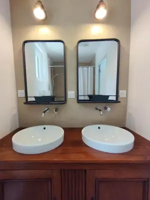 a bathroom with two sinks and two mirrors at Le Petit Paradis in Saint-Martin-de-Castillon