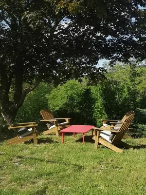 three chairs and a picnic table in the grass at Le Petit Paradis in Saint-Martin-de-Castillon