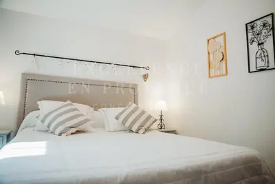 a bedroom with a large white bed with striped pillows at Mas de l'air in Noves