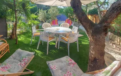 a table and chairs under an umbrella in a yard at 3 Bedroom Awesome Home In Carpentras in Carpentras