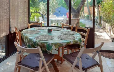 a dining room table with chairs and a table with a tablecloth at 3 Bedroom Awesome Home In Carpentras in Carpentras