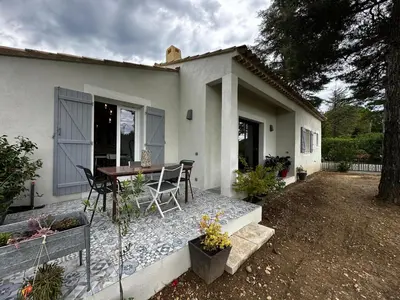 a small white house with a table and chairs at Le refuge des oiseaux in Lourmarin