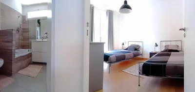 a bedroom with two beds and a bathroom at Villa Lambesc Provence in Lambesc