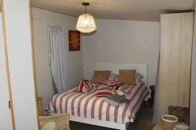 a bedroom with a bed and a chandelier at Maison provençale avec piscine in Loriol-du-Comtat