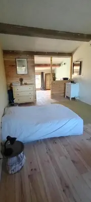 a large bedroom with a large bed and a chair at JAS provençal pour 6 personnes à 2mn de la Grange de Javon in Monieux