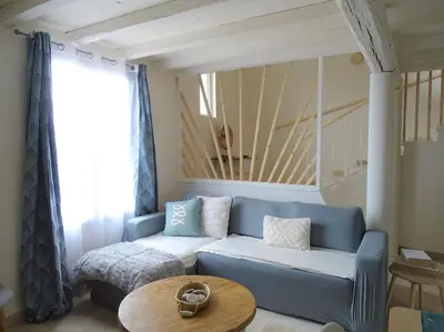a living room with a blue couch and a table at Maison avec terrasse panoramique in Châteauneuf-de-Gadagne