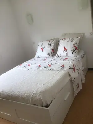 a white bed with white sheets and red crabs on it at Ayoug Chambre Individuelle Chez Habitat in Carpentras