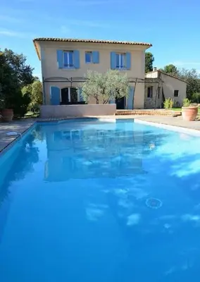 a large blue swimming pool in front of a house at Villa au calme et sans vis à vis , proche du village in La Bastide-des-Jourdans