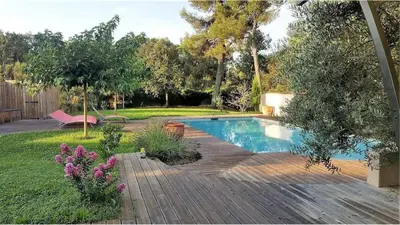 a swimming pool in a yard with a wooden deck at Villa au calme et sans vis à vis , proche du village in La Bastide-des-Jourdans