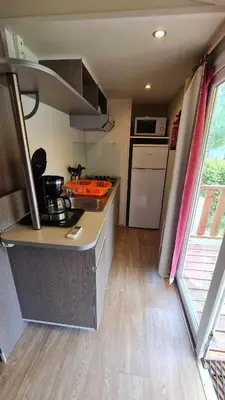 a small kitchen with a stove and a counter top at Mobil Home au calme Camping 4 Cadenet in Cadenet