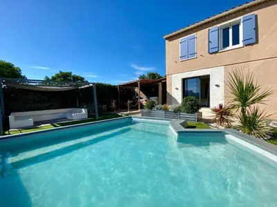 a swimming pool in front of a house at La Bella Vista in Villelaure