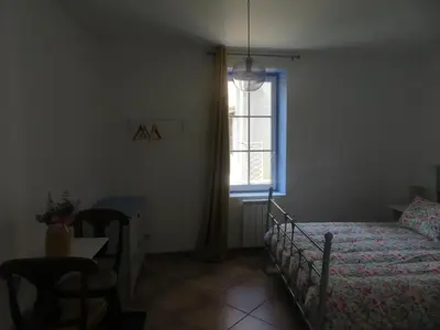 a bedroom with a bed and a window and a table at Auberge de la petite casserole in Revest-des-Brousses