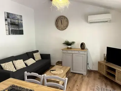 a living room with a couch and a clock on the wall at Mazet provençal in Eyguières
