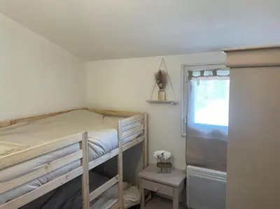 a small bedroom with a bunk bed and a window at Mazet provençal in Eyguières