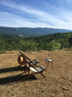 a chair and a hat sitting on top of a field at Luberon Provence Swimming pool Terrace View for 2 in Viens